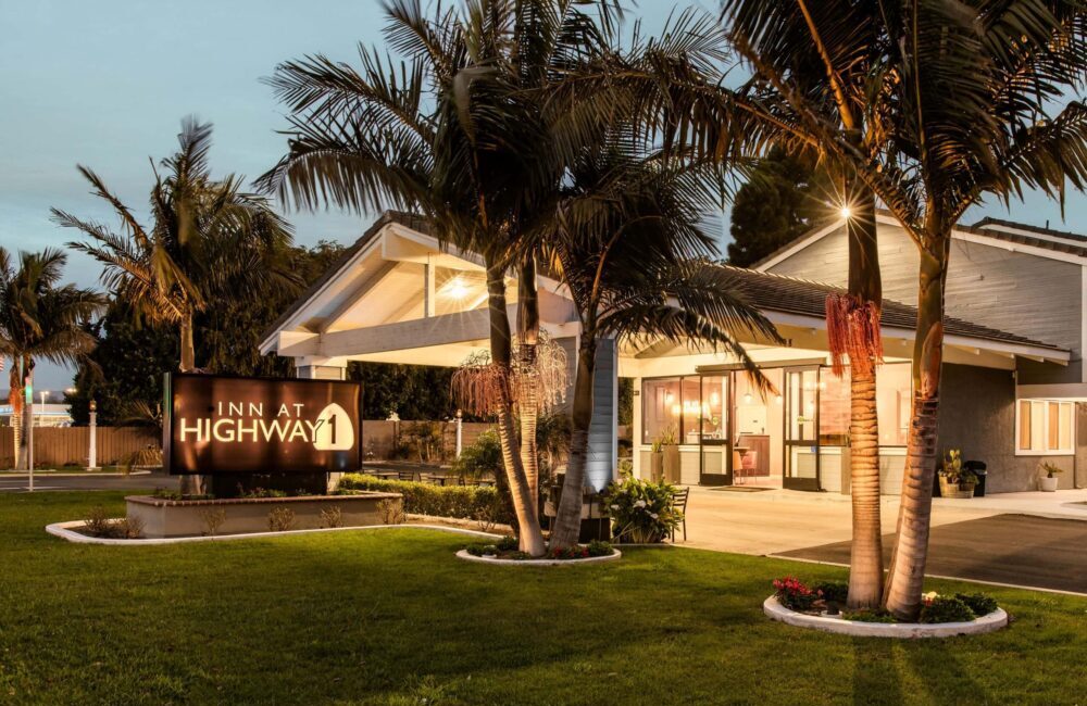 Charming hotel entrance in Lompoc, California with palm trees and outdoor signage.