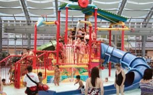 Kids wait their turn going down a brightly colored indoor waterslide