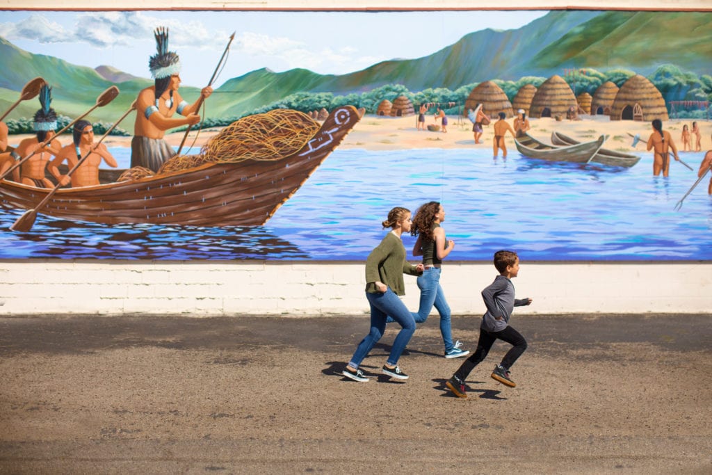 Kids running past mural in Lompoc