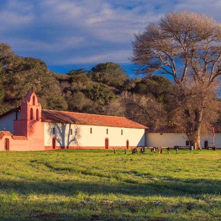 La Purisma Mission glows brightly and ochre at sunset