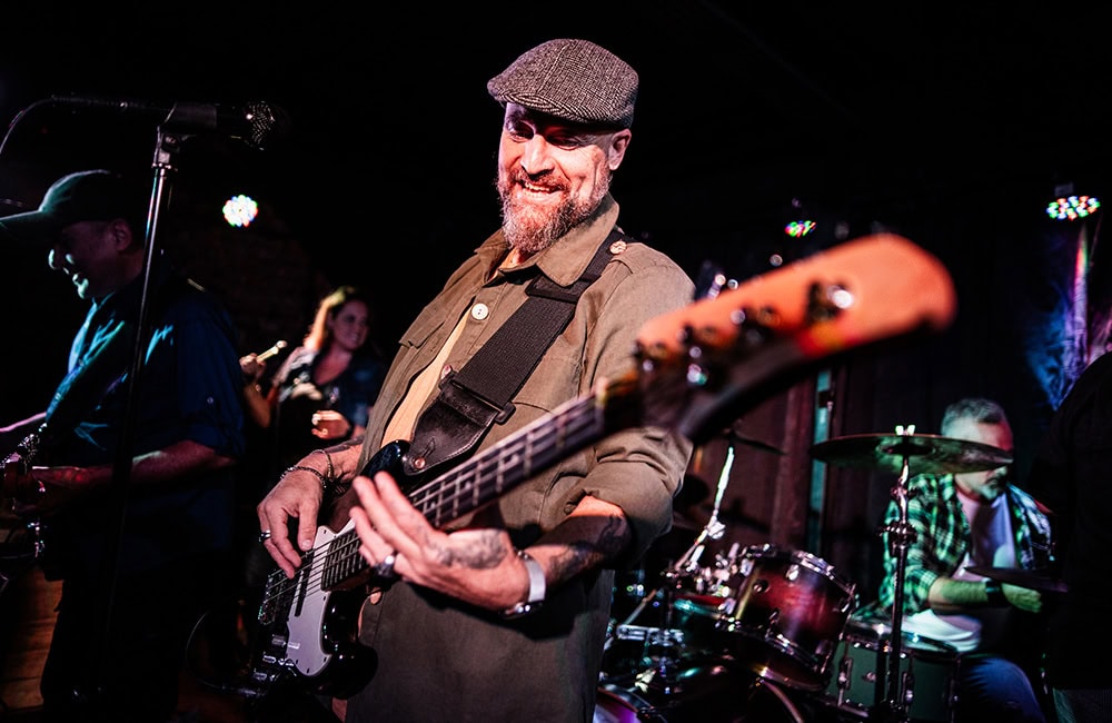 Musicians playing live on stage in Lompoc California with vibrant lighting.