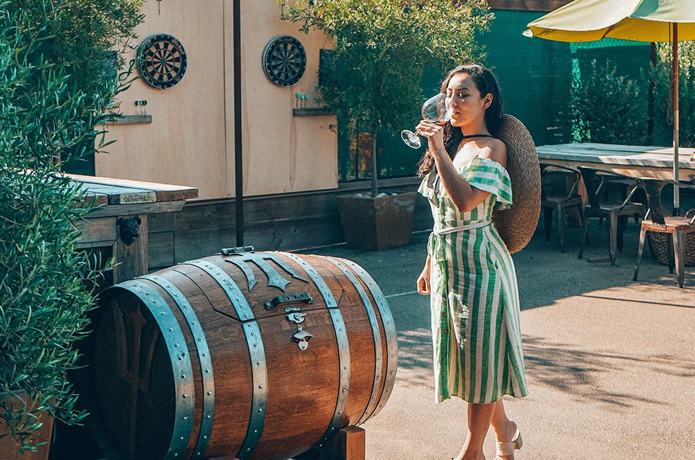 A woman in a striped sundress sips from her glass in the late afternoon light at Montemar Wines (photo: Cherise Masukawa)