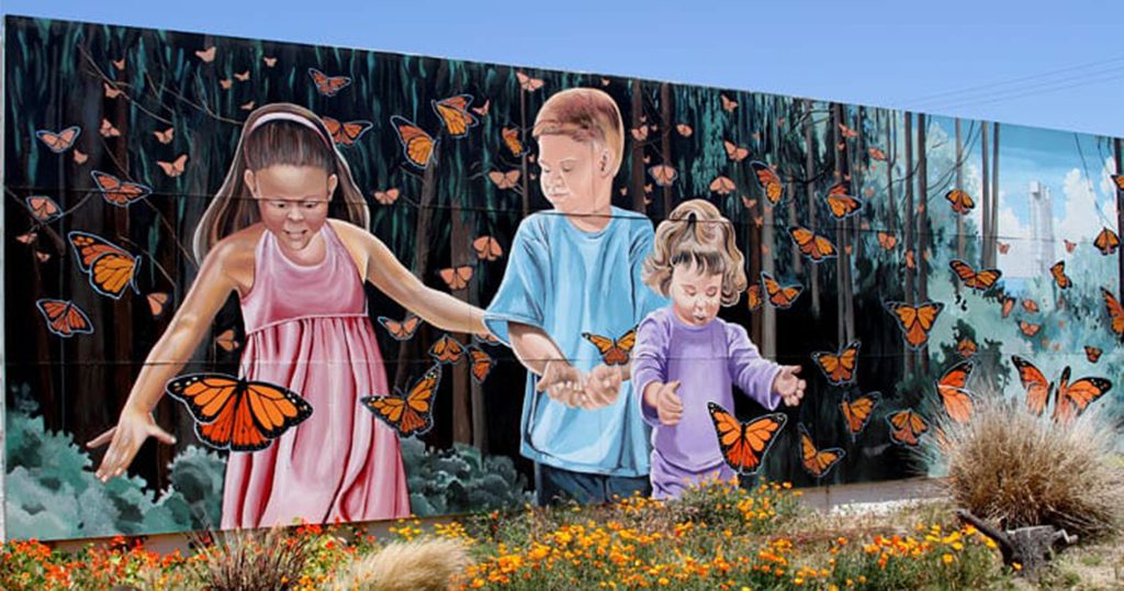 The "Monarch Magic" mural, depicts three smiling children surrounded by monarch butterflies