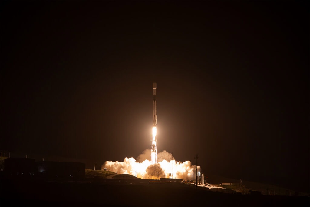 Rocket launch at night in Lompoc, California with bright flames and smoke.
