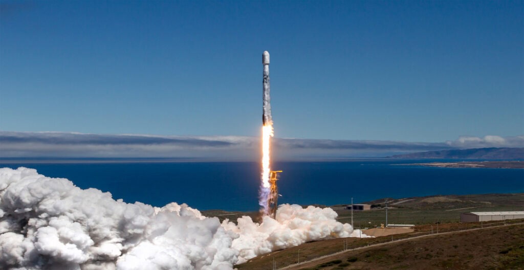 Rocket launching from Lompoc, California with ocean view in background.