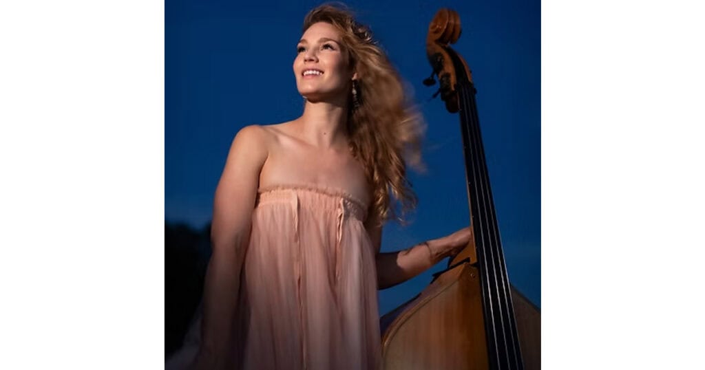 Woman playing double bass outdoors in Lompoc, California at sunset.