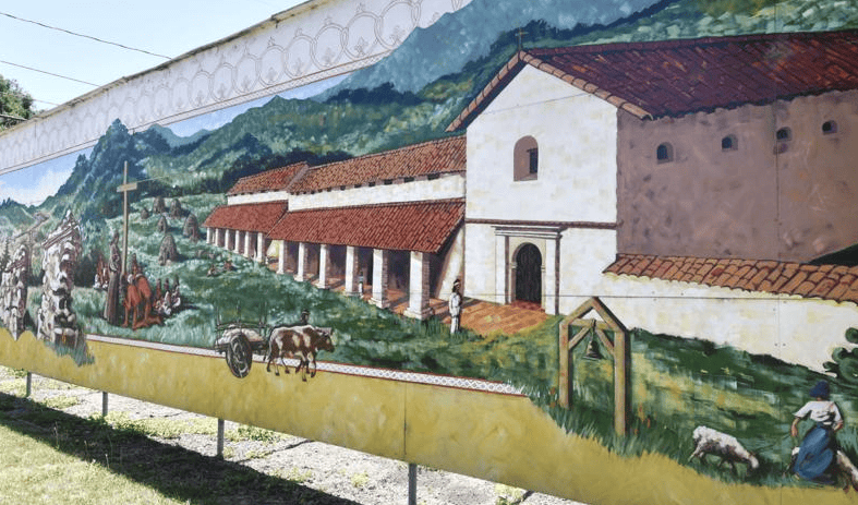 Colorful mural depicting historic buildings and farmers in Lompoc, California.