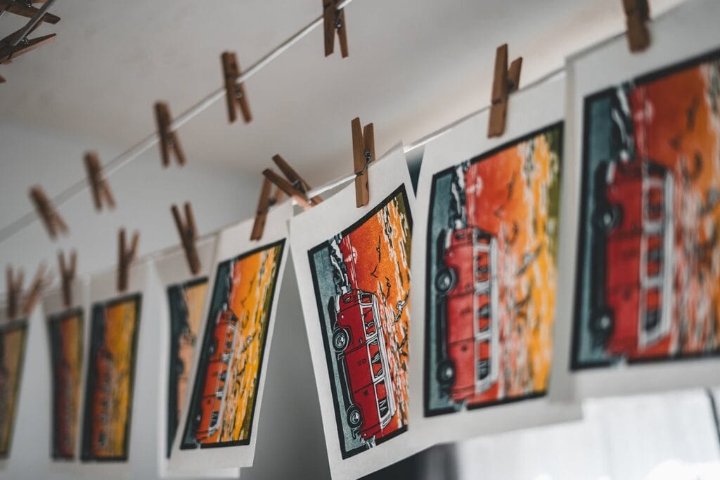 Photographs of vintage red buses displayed at Lompoc art event.